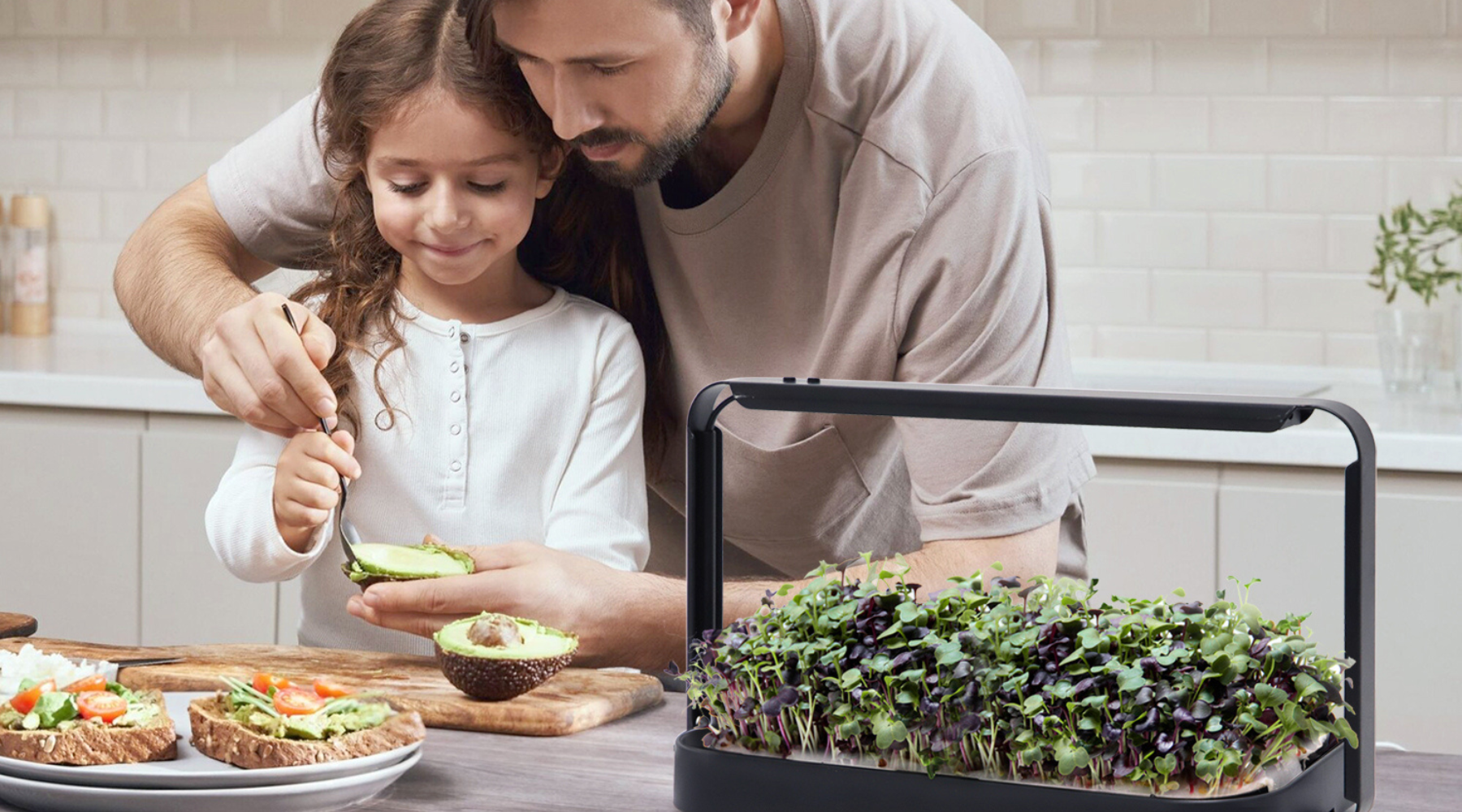 Man and child preparing food together with a small garden on a kitchen counter.