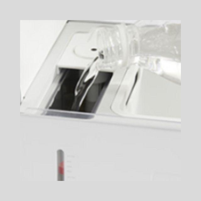 Filling the water reservoir of the Smart Mushroom Growing Box from a bottle